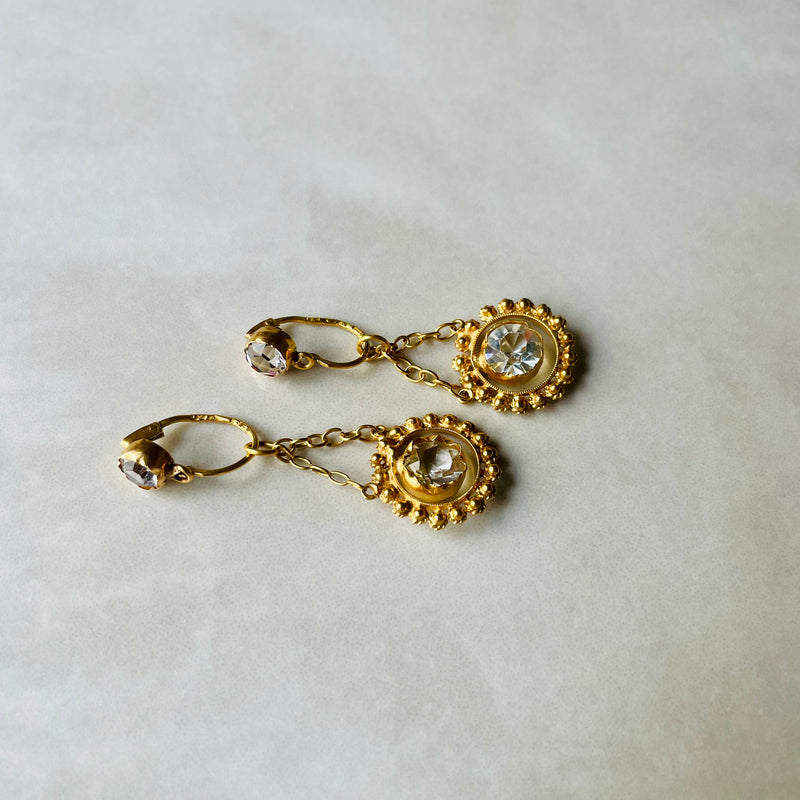 Gold earrings with gemstones on a light background
