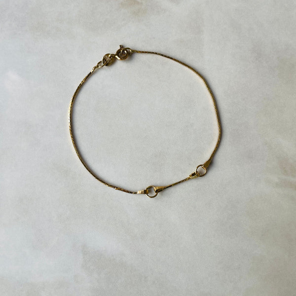 Gold bracelet on a light gray background | Deheb Jewellery Malta