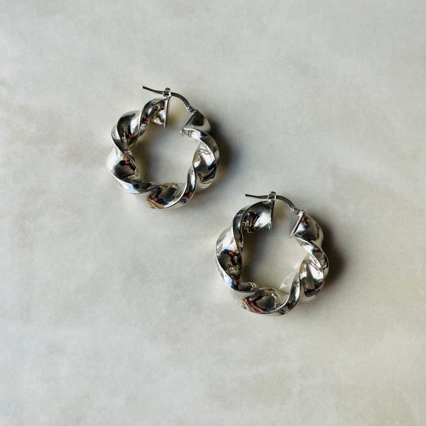 Pair of silver hoop earrings on a light gray background