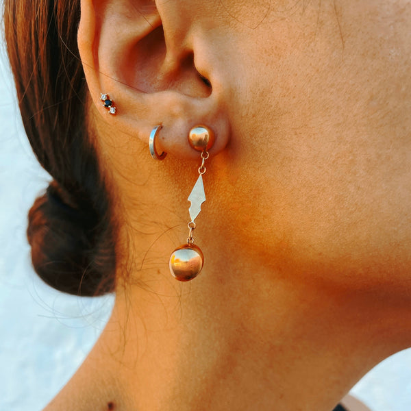 Close-up of dangling gold earring.