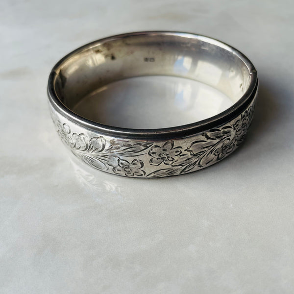 Embossed silver bangle on grey surface| Deheb Malta Jewellery