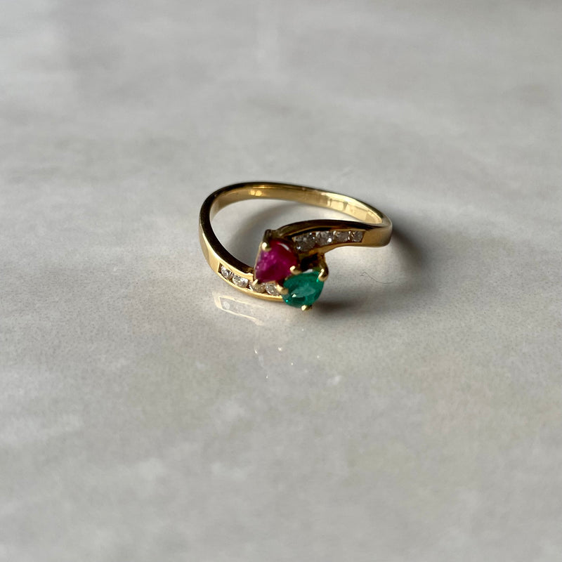 Emerald and ruby ring on grey background