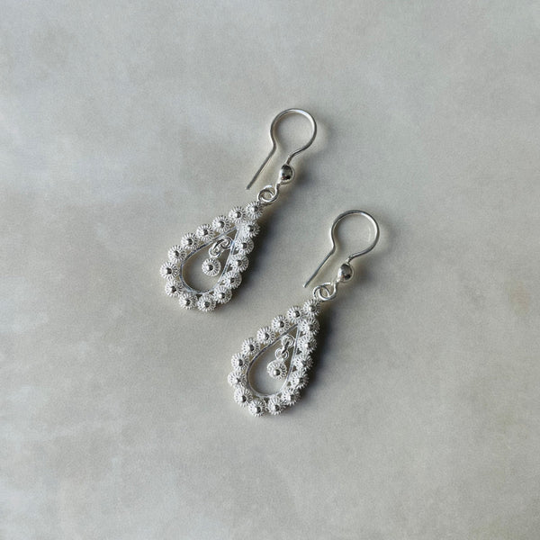 Silver teardrop earrings with intricate designs on a light gray background | Deheb Jewellery Malta