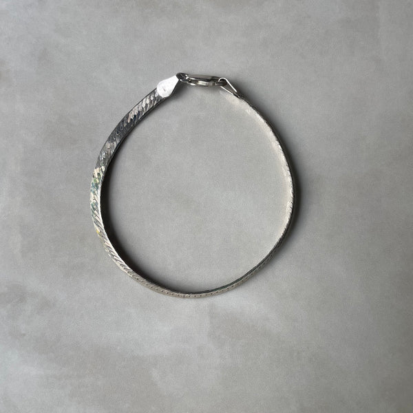 Silver bracelet on a gray background