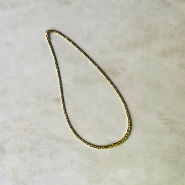 Gold chain necklace on a light beige surface | Deheb Malta Jewellery