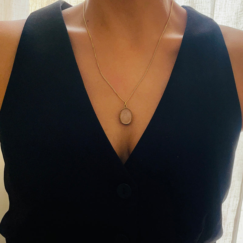 Model wearing gold necklace featuring a glass pendant | Deheb Jewellery Malta