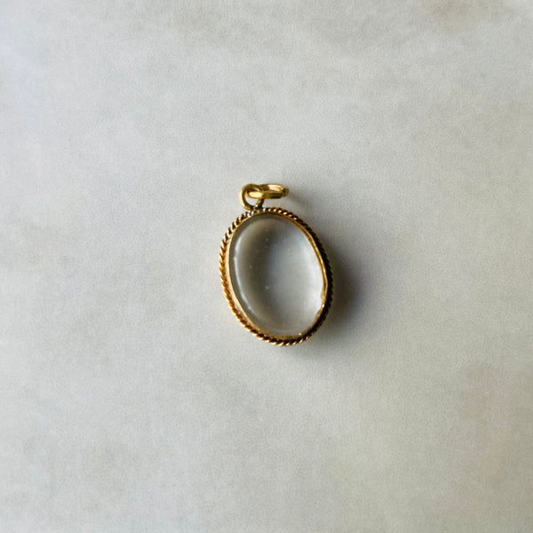 Gold pendant on a light gray background