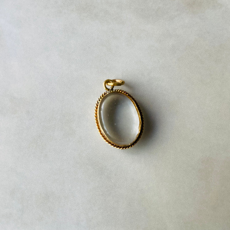 Gold pendant on a light gray background