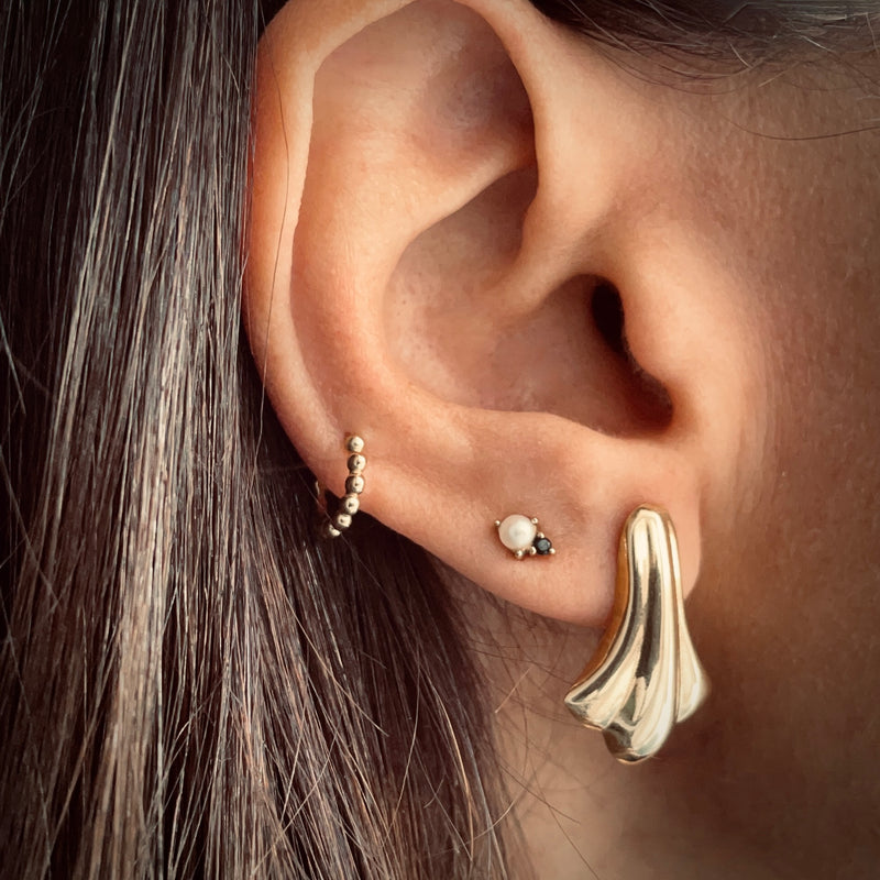 Gold stud earring on model 