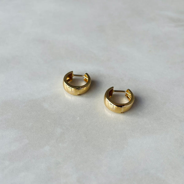 Gold hoop earrings on a light gray background | Deheb Malta Jewellery