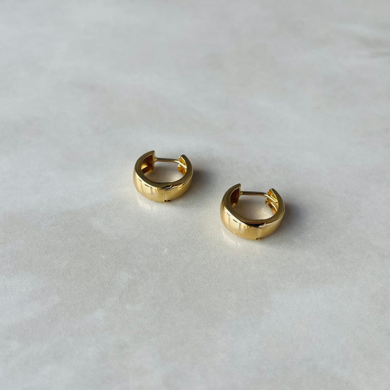 Gold hoop earrings on a light gray background | Deheb Malta Jewellery
