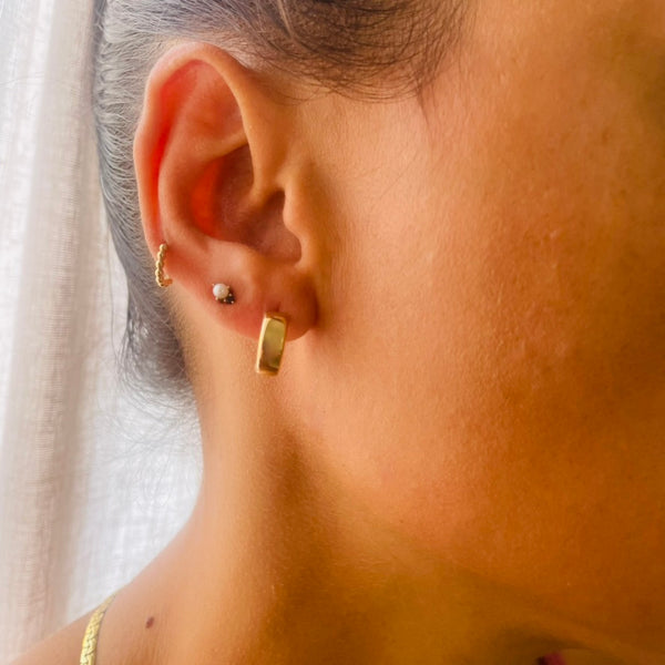 Close-up of an ear wearing gold hoop earrings on model | Deheb Jewellery Malta