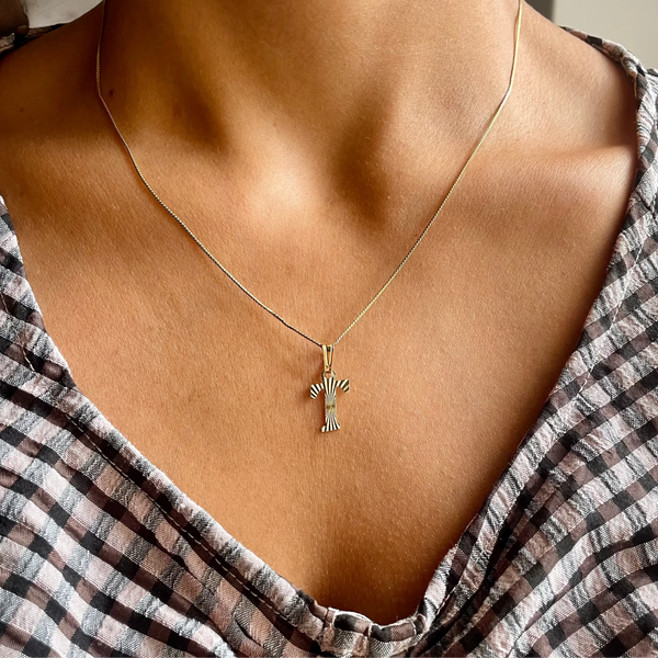 Necklace with a pendant worn by a person in a striped garment