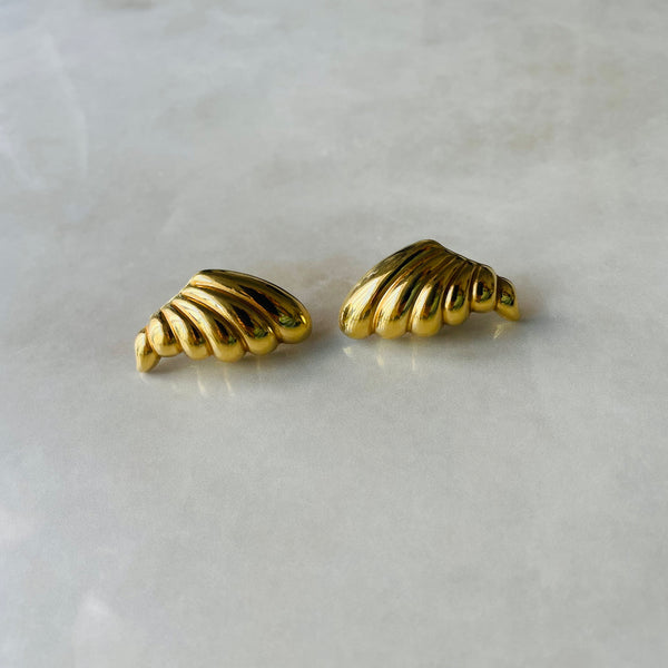 Pair of gold cornucopia-shaped earrings on a light gray background