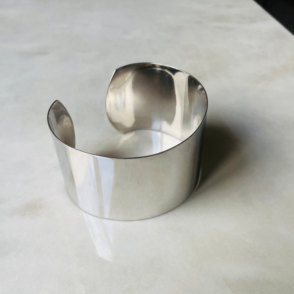 Silver bracelet on a light gray surface