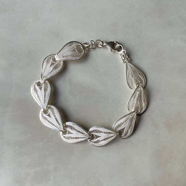 Silver bracelet with leaf-like patterns on a gray background | Deheb Jewellery Malta