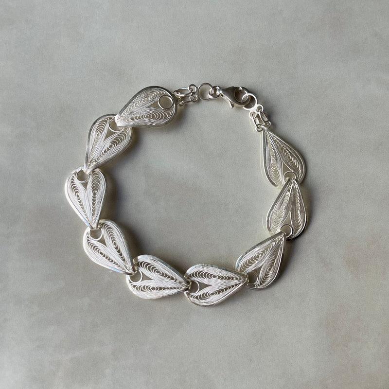 Silver bracelet with leaf-like patterns on a gray background | Deheb Jewellery Malta