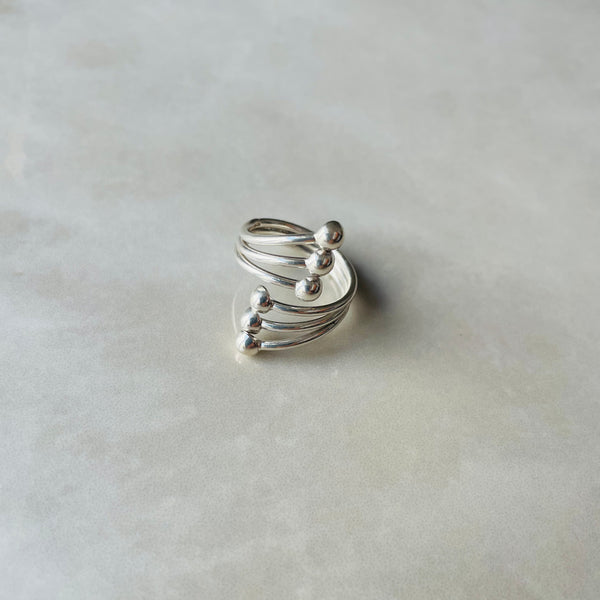 Silver spiral lifestyle long  on grey surface| Deheb Malta Jewellery