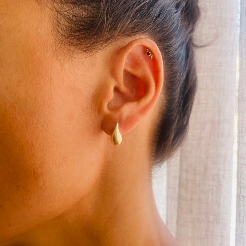 Close-up of an ear wearing a gold earring on model | Deheb Jewellery Malta