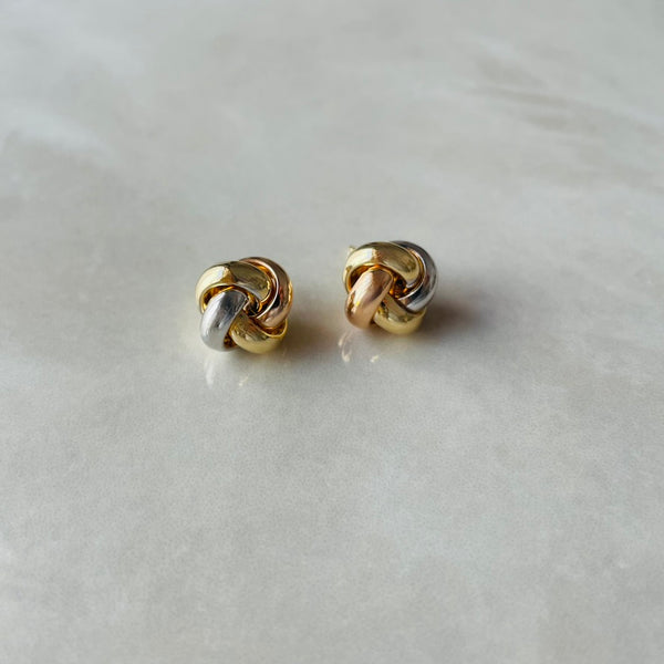Pair of gold knot earrings on a light gray background | Deheb Malta Jewellery