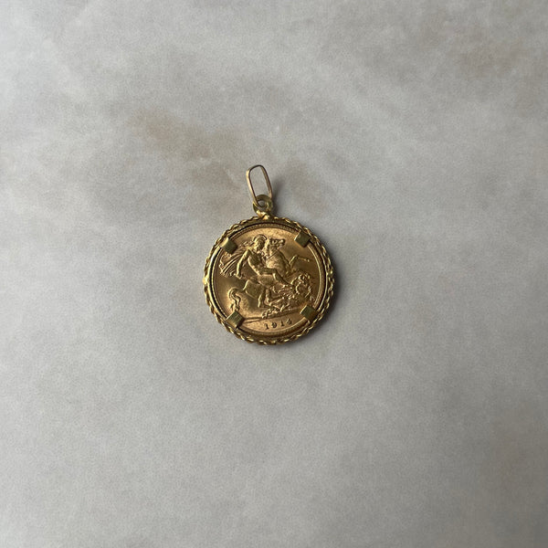 A 22 carat gold coin pendant featuring a historical figure and a dragon, set in an 18 carat gold ring.